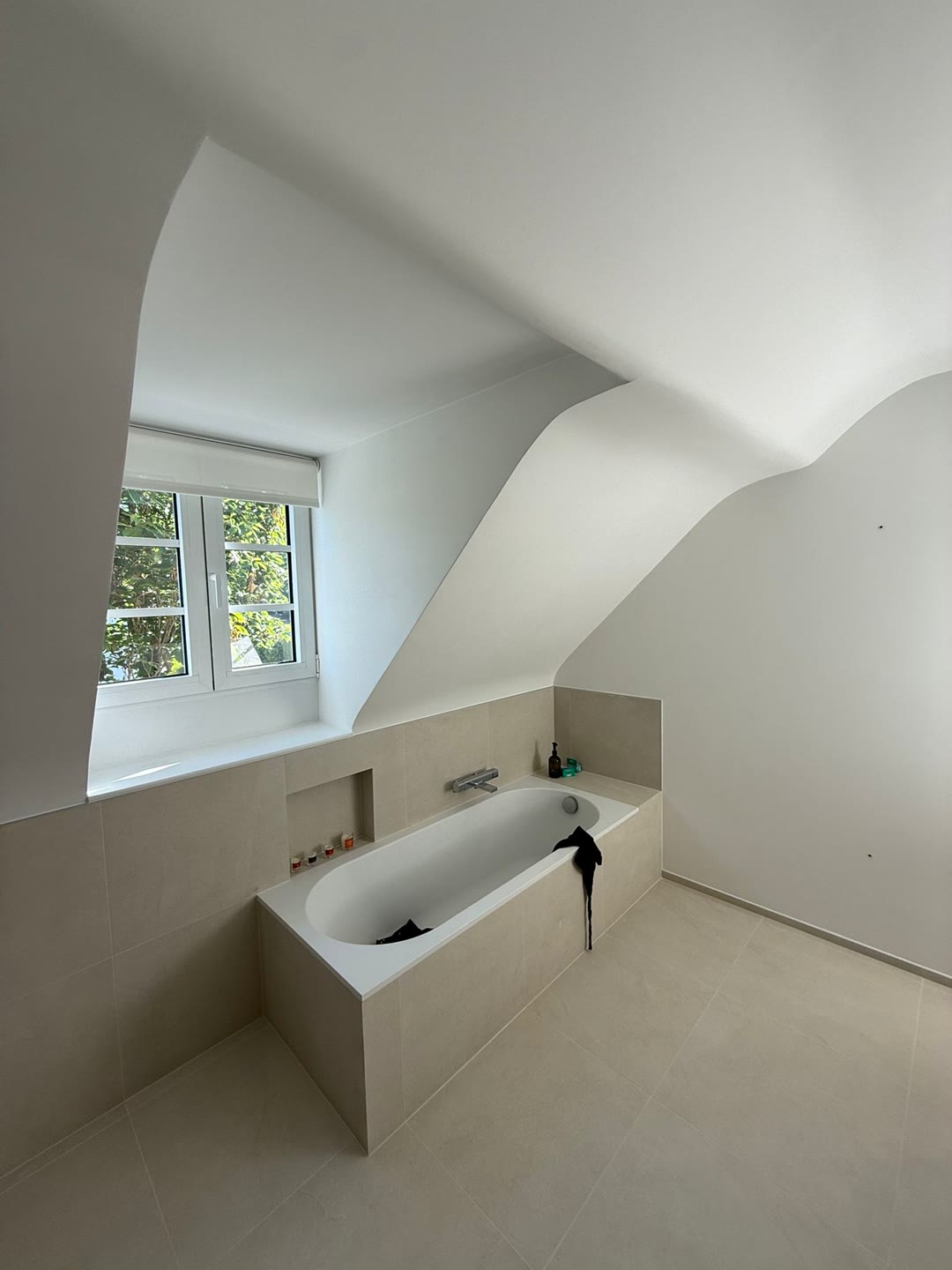 Salle de bain rénovée avec baignoire encastrée et niche carrelée