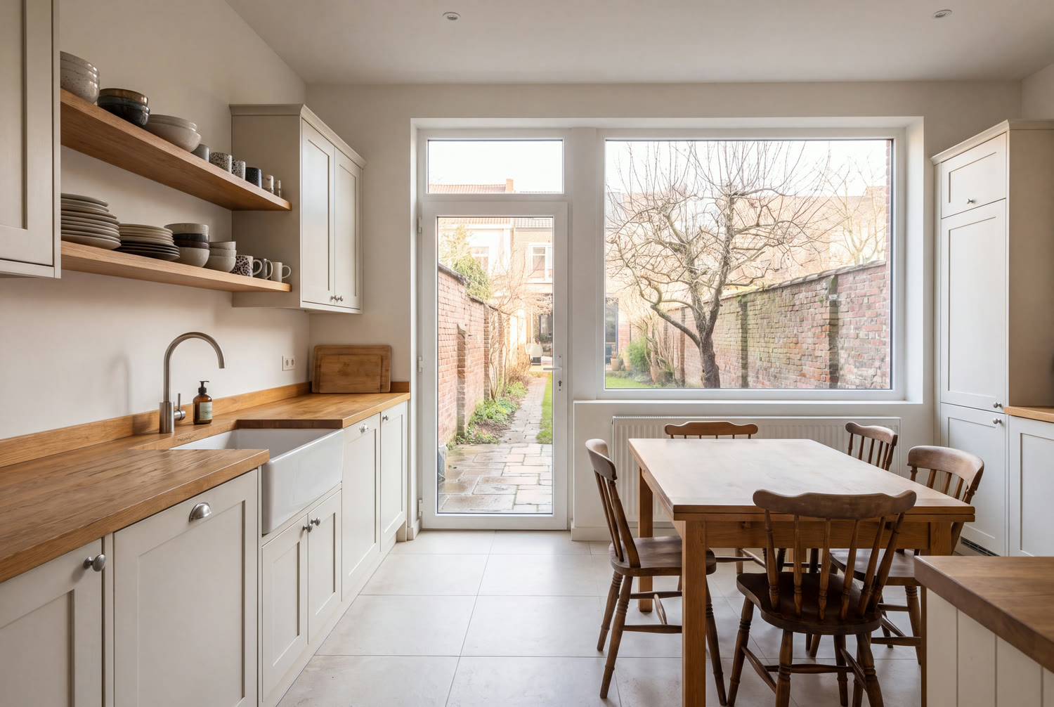 Cuisine familiale rénovée dans une maison de Forest, plan en chêne et porte vitrée sur le jardin