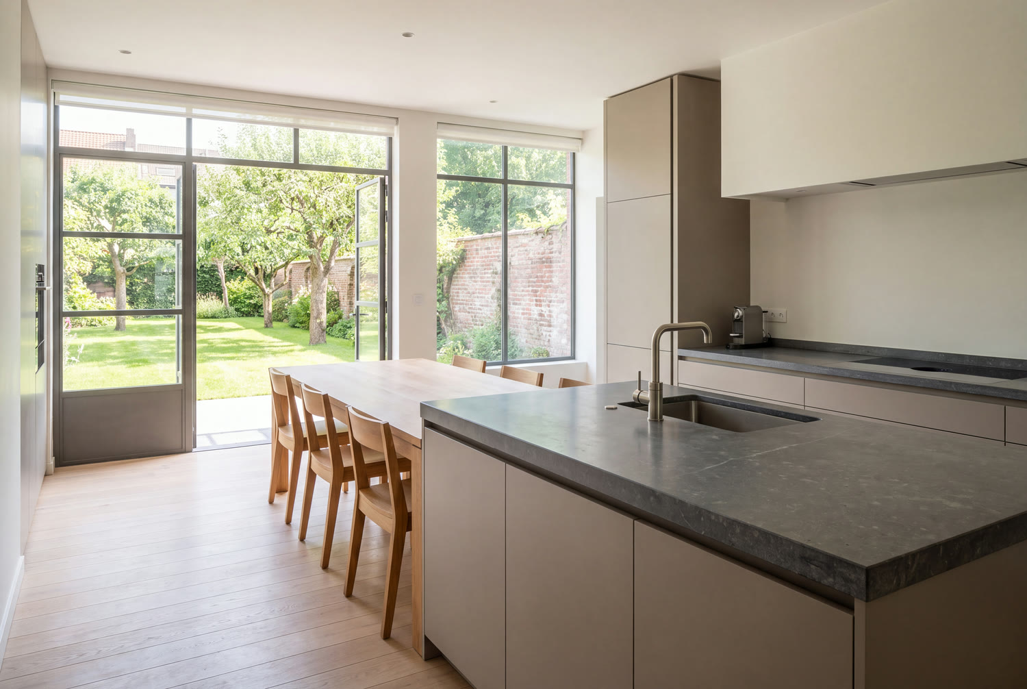 Cuisine rénovée d'une villa d'Uccle en pierre bleue, ouverte sur le jardin