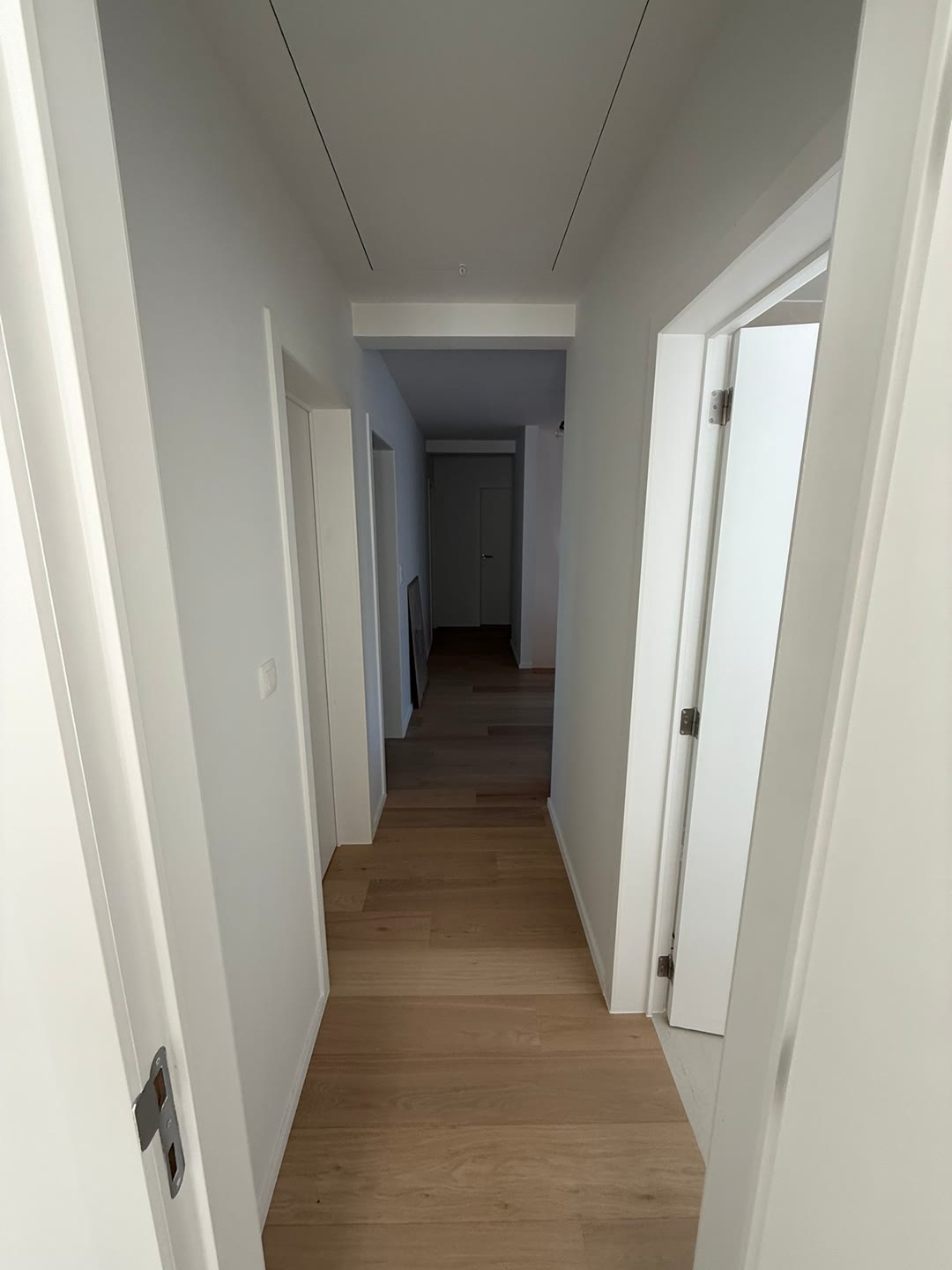 Couloir rénové avec enduit lisse blanc et parquet chêne