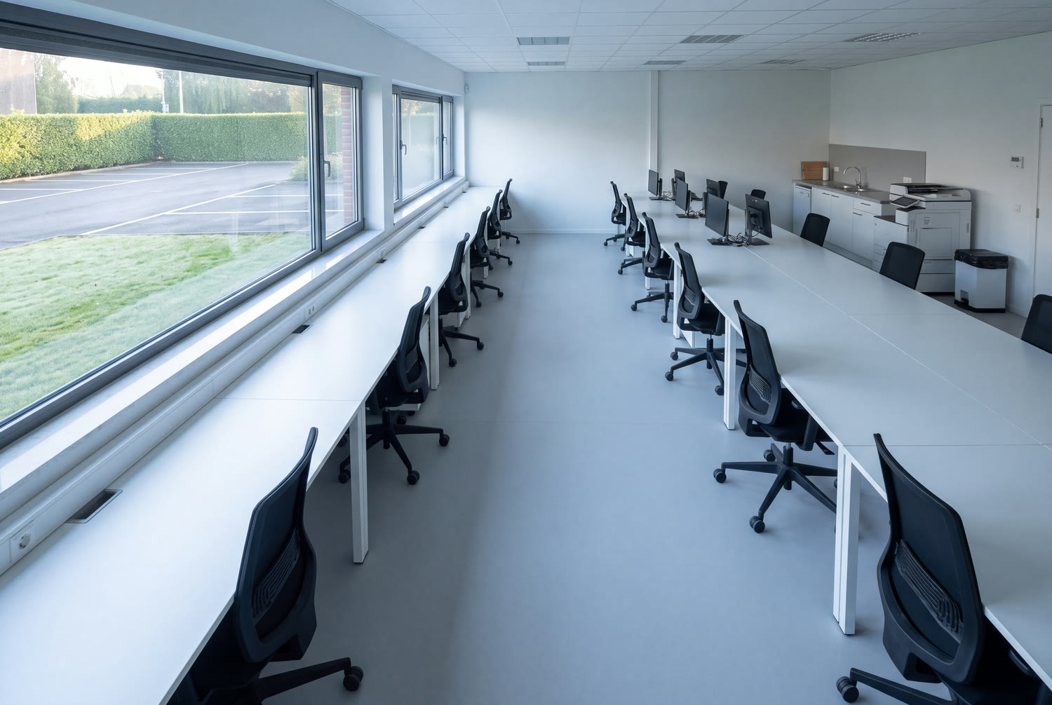 Office floor of a Wavre SME unit at daybreak, desks cleared and floor without streaks