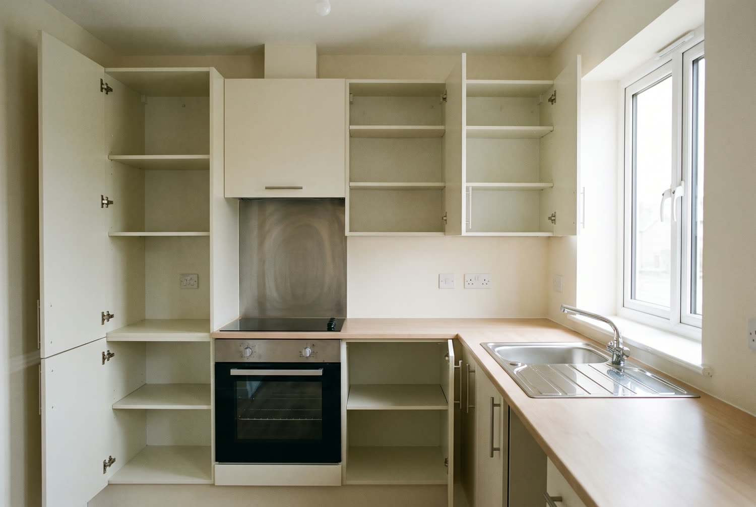 Cuisine de logement locatif nettoyée pour l'état des lieux, four dégraissé, meubles vidés et évier détartré